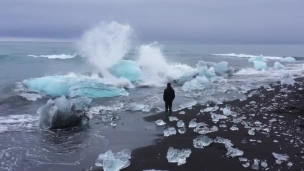 Ένας Άντρας Βλέπει Κύματα Πέφτουν Πάνω Στα Μπλε Παγόβουνα Στην — Αρχείο Βίντεο