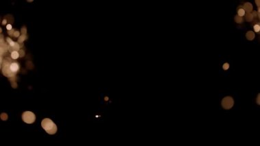 Blurred bokeh lighting effects from burning sparklers on the left and right side of the frame in slow motion