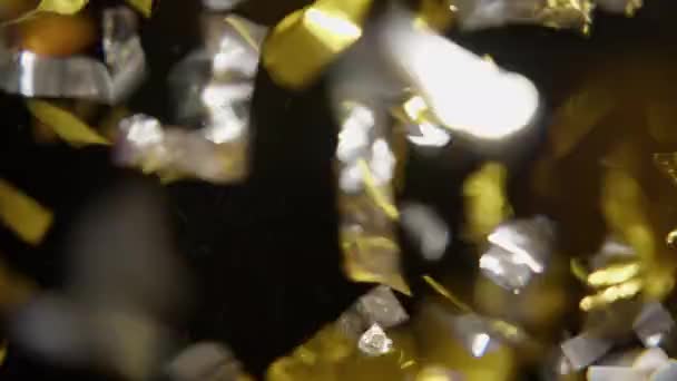 Eine Nahaufnahme Von Flatterndem Silber Und Goldkonfetti Auf Dunklem Hintergrund — Stockvideo