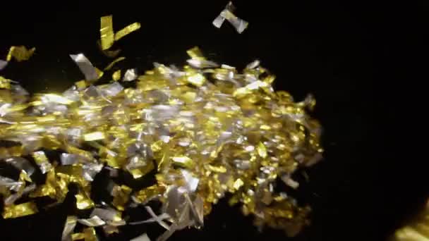 Geblasenes Gold Und Silberkonfetti Auf Schwarzem Hintergrund — Stockvideo