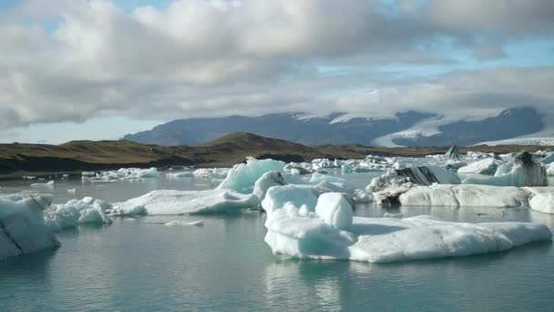 アイスランドのジョクルサロン氷河ラグーンの氷山を示す 左から右へ移動する昼間のパンショット — ストック動画