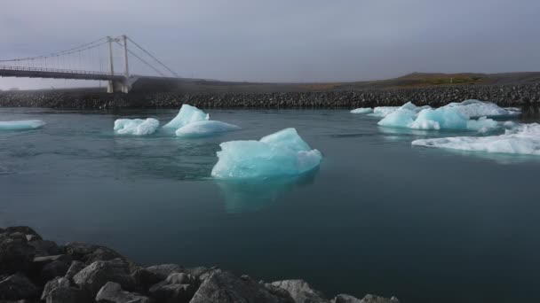 アイスランドのジョクルサロン氷河ラグーンの浮遊氷山を示す堤防からの静止したショット — ストック動画