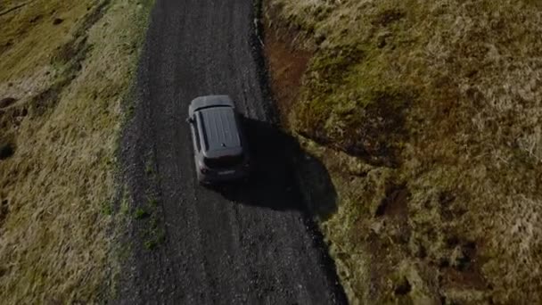 아이슬란드 집들을 수있는 바위투성이 도로를 여행하는 자동차의 — 비디오