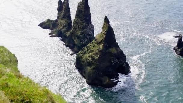 アイスランドの昼間に鳥が飛んでいるレイニストランガー海のスタックを示す空中ビュー — ストック動画