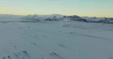 Wide shot of the winter landscape and snow-covered mountains of Iceland during daytime