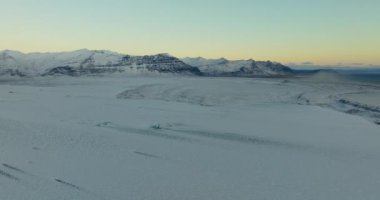 Wide pan shot of the winter landscape and snow-covered mountains of Iceland during daytime