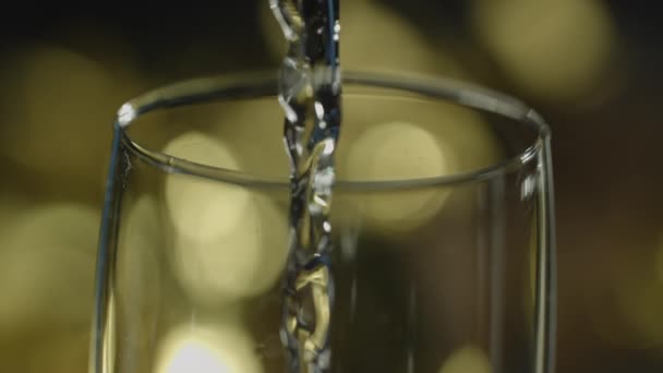 シャンパンとフルートガラスの縁のクローズアップショットは ボケを背景に ゆっくりと注がれています — ストック動画