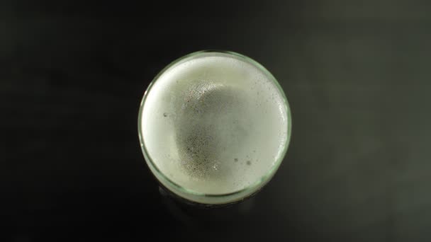 在黑暗的背景下 用慢镜头拍摄的香槟酒泡沫和泡沫在长笛玻璃杯边缘爆裂的倒影 — 图库视频影像