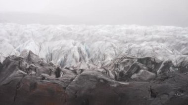 Pan, İzlanda 'nın Skaftafell şehrinde gündüz vakti Svinafelljokull buzulunun puslu bir görüntüsünü göstererek soldan sağa hareket eder.