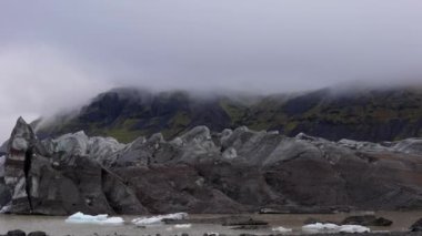 Pan, Skaftafell, İzlanda 'da gündüz vakti sisli manzarayı ve Svinafellsjokull buzulunu göstererek soldan sağa hareket eder.