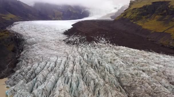 アイスランドのSkaftafellにある茶色のSvinafellsjokull氷河と山脈を示す昼間の後退する空中ショット — ストック動画