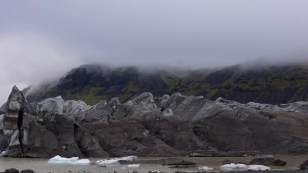 アイスランドのスカフタフェルで昼間に霧深い風景とSvinafellsjokull氷河を示す左から右に移動するパンショット — ストック動画