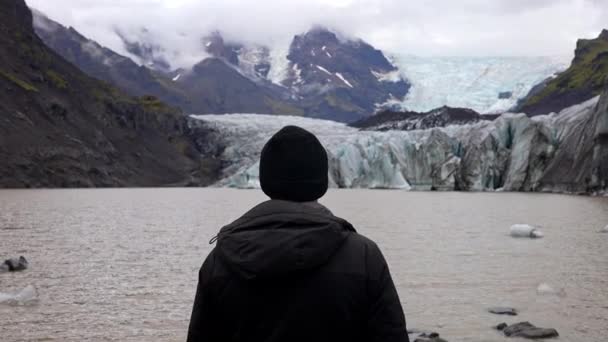 アイスランドのSkaftafellで昼間にSvinafellsjokull氷河と霧に覆われた風景を見ている人のバックビュー — ストック動画