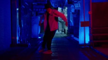 Bir adam Bangkok 'tan ağır çekimde breakdance müziği eşliğinde dans ediyor.