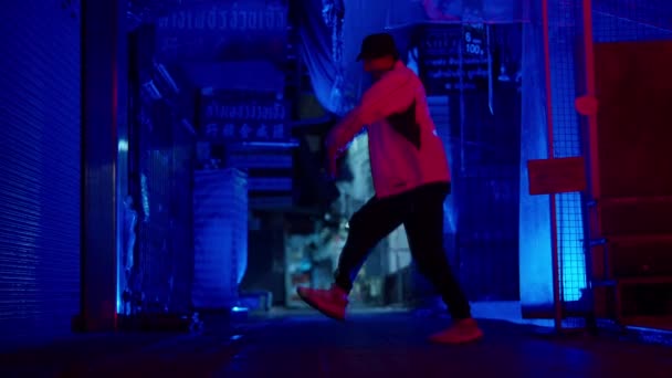 スタイリッシュなジャケットと帽子を身に着けている男リズミカルな手と足のブレークダンスは青い路地でスローモーションで動きます — ストック動画
