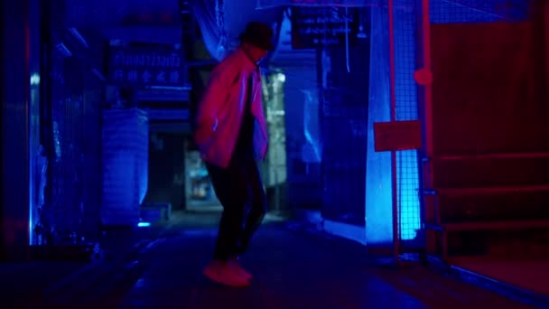 青い背景を背景に複雑なブレイクダンスのルーチンを練習しているバンコクの路地で男のゆっくりとした動き — ストック動画