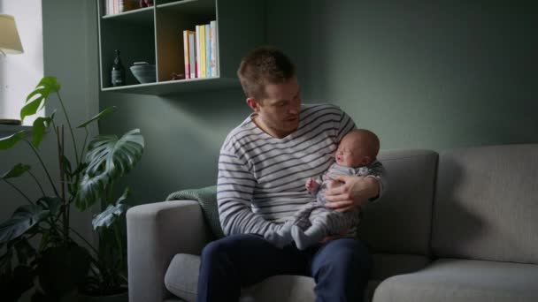 Muž Sedící Pohovce Kolébá Houpe Novorozeně Náručí Předtím Než Vloží — Stock video