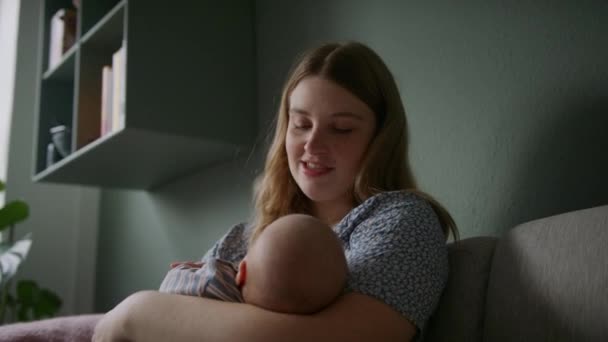 一个母亲坐在家里的沙发上对着婴儿唱歌的中景照片 — 图库视频影像