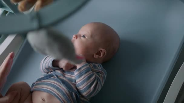 赤ちゃんのおむつを変更する準備をしている母親のぶら下がりベビーベッドの携帯電話の後ろから撮影トップビュー — ストック動画