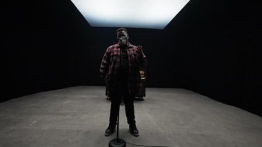 Bir kamera mikrofona şarkı söyleyen bir adama yaklaşır. Arkasından piyano çalan bir adamı orta açıyla gösterir.