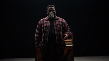 Stüdyoda karanlık bir geçmişi olan duygusal bir şarkı söylerken göğsüne dokunan bir adamın Dolly çekimi.