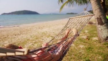 Tayland 'da güneşli bir günde hamakta yatan bir çocuk.