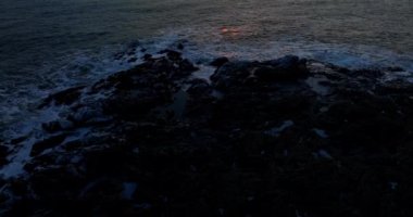 Kayalık kıyıların, sakin suların ve İzlanda 'da günbatımının hava görüntüsü.