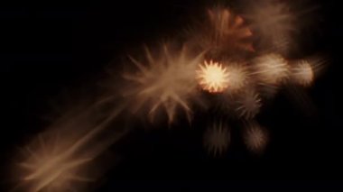 Bulanık yıldız şekilli aydınlatma efektleri, yanan bir maytapın koyu arkaplan üzerine yansımasıdır.