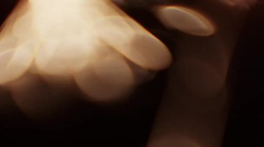 Karanlık bir arkaplanda yanan bir maytaptan çıkan bulanık bokeh ışıklarının yakın çekimi