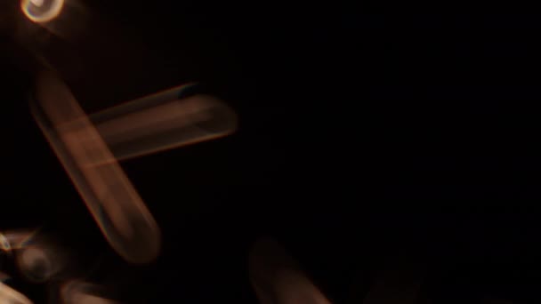 暗い背景を背景にフレームの左側にスパイラルライトを生成する燃える輝き — ストック動画
