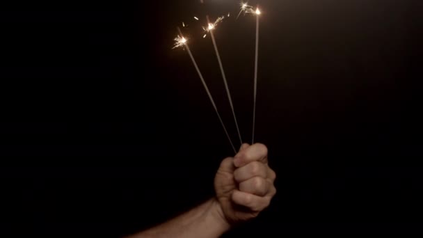 Hand Hebt Drei Brennende Wunderkerzen Vor Dunklem Hintergrund — Stockvideo