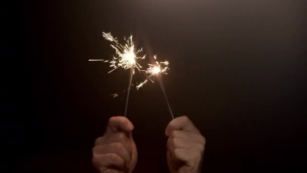 暗い背景に燃える輝きの2組の手を揺れるビデオ — ストック動画