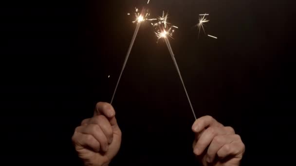 暗い背景に2組の燃える輝きを持つ手を示すビデオ — ストック動画