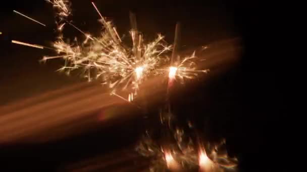 Zwei Brennende Wunderkerzen Die Verschwommenes Goldenes Diagonales Licht Vor Dunklem — Stockvideo