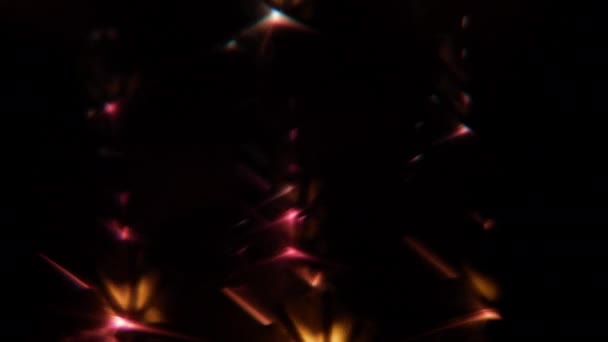 暗い背景の下でぼやけた金とピンクの光の効果を生み出す燃える輝き — ストック動画