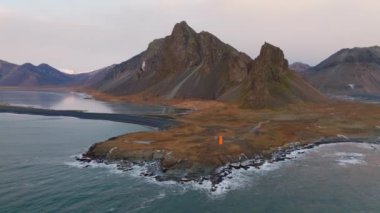 Krossanesfjall dağ sırası ile Eystrahorn 'un hava manzarası ve İzlanda' da gündüz vakti yakın bir siyah kum plajı.