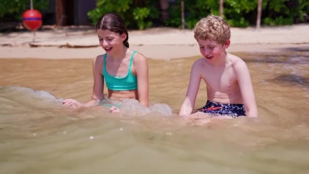 Відео Хлопчик Дівчинка Сидять Пляжі Збираючи Воду Пісок Руками Під — стокове відео