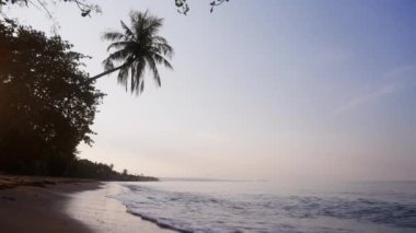 Bulutlu mavi gökyüzü ve deniz dalgaları Tayland 'da bir sahil şeridine doğru koşuyor.