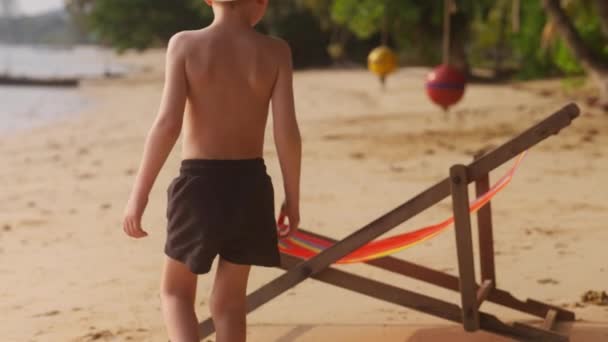 Stále Záběr Ukazuje Mladého Chlapce Kráčejícího Směrem Lehátku Pláži Během — Stock video