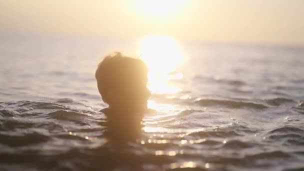 泰国落日时分 一名男童在平静的海水中游泳的照片 — 图库视频影像