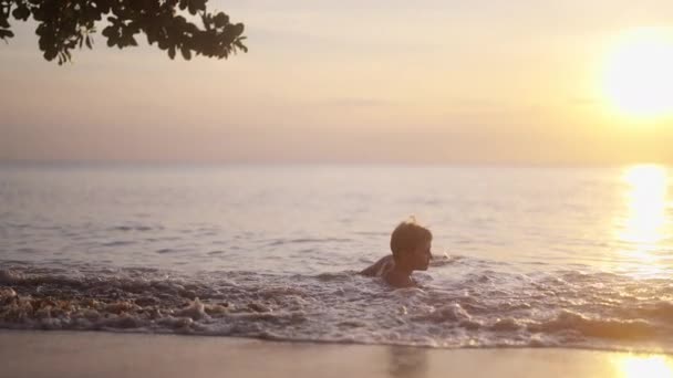 在泰国 一个视频展示了一个男孩日落时坐在岸边的轮廓 — 图库视频影像