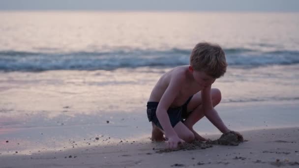 在泰国 一个男孩日落时在海滩上玩沙子的视频 — 图库视频影像