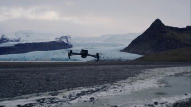 Alçaktan uçan bir dron İzlanda 'daki buzulların yakınındaki bir tarlanın üzerinde uçuyor.