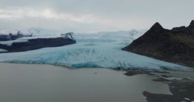 İzlanda 'da bir vadideki donmuş buzul oluşumlarının manzaralı görüntüsü.