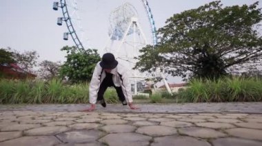 Profesyonel bir break dansçı parkta kompleks bir hip hop dansı yapar.