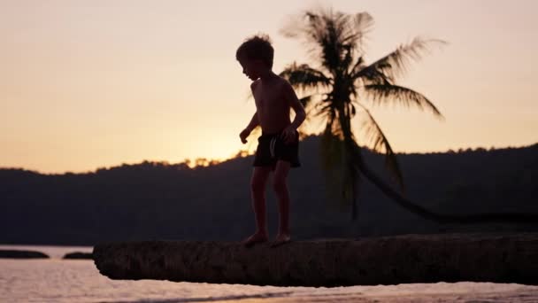 Gün Batımında Tayland Bir Sahilde Ağaç Gövdesinden Atlayan Bir Çocuğun — Stok video