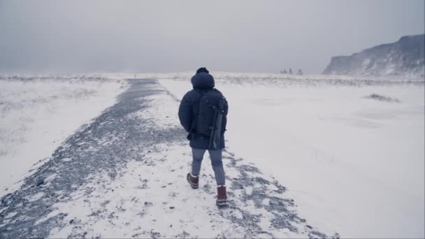 Voltar Vista Tiro Homem Caminhando Terreno Nevado Reynisfjara Islândia Durante — Vídeo de Stock
