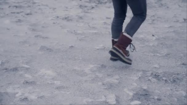 在一个寒冷的冬日 一个男人在冰岛的雷尼斯法哈拉的雪地上行走时 相机拍到了他的靴子 — 图库视频影像