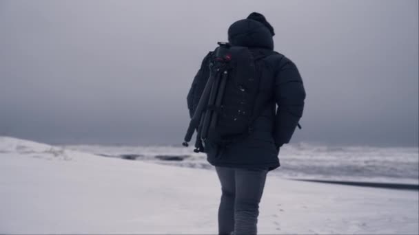 Widok Tyłu Człowieka Chodzącego Śniegu Nad Brzegiem Plaży Reynisfjara Islandii — Wideo stockowe