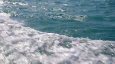 Tayland 'da bulunan okyanusta güneş parlayan yüzey dalgalarını gösteren bir video.